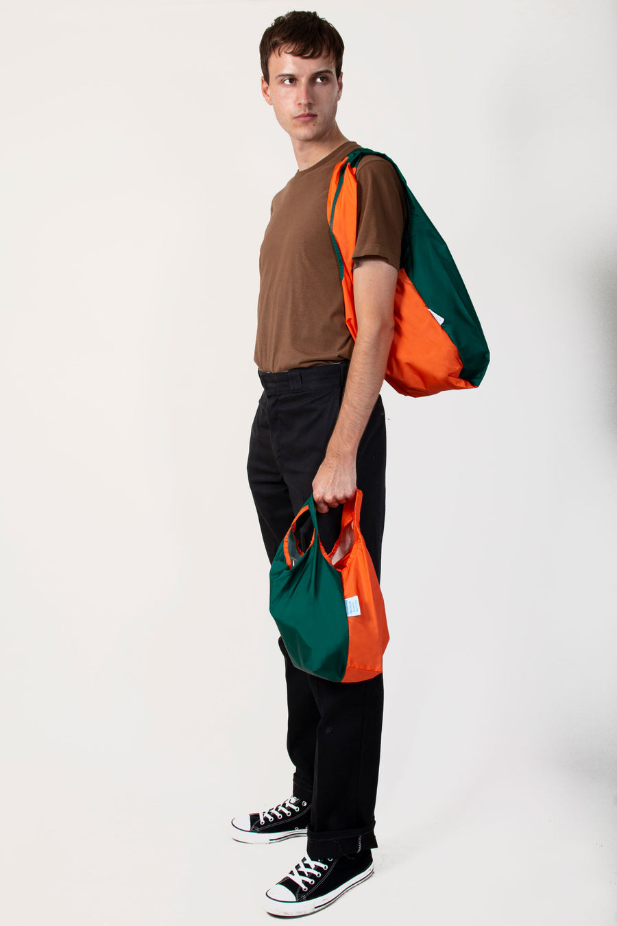 Kind Bag Bi-Colour Orange and Green Reusable Bag, on shoulder whilst holding mini